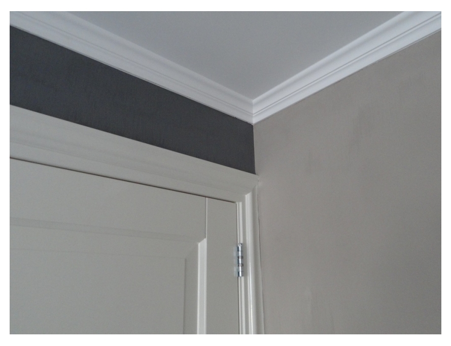 Detail spuitwerk plafond en schilderwerk sierlijst en deur