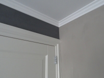 Detail spuitwerk plafond en schilderwerk sierlijst en deur